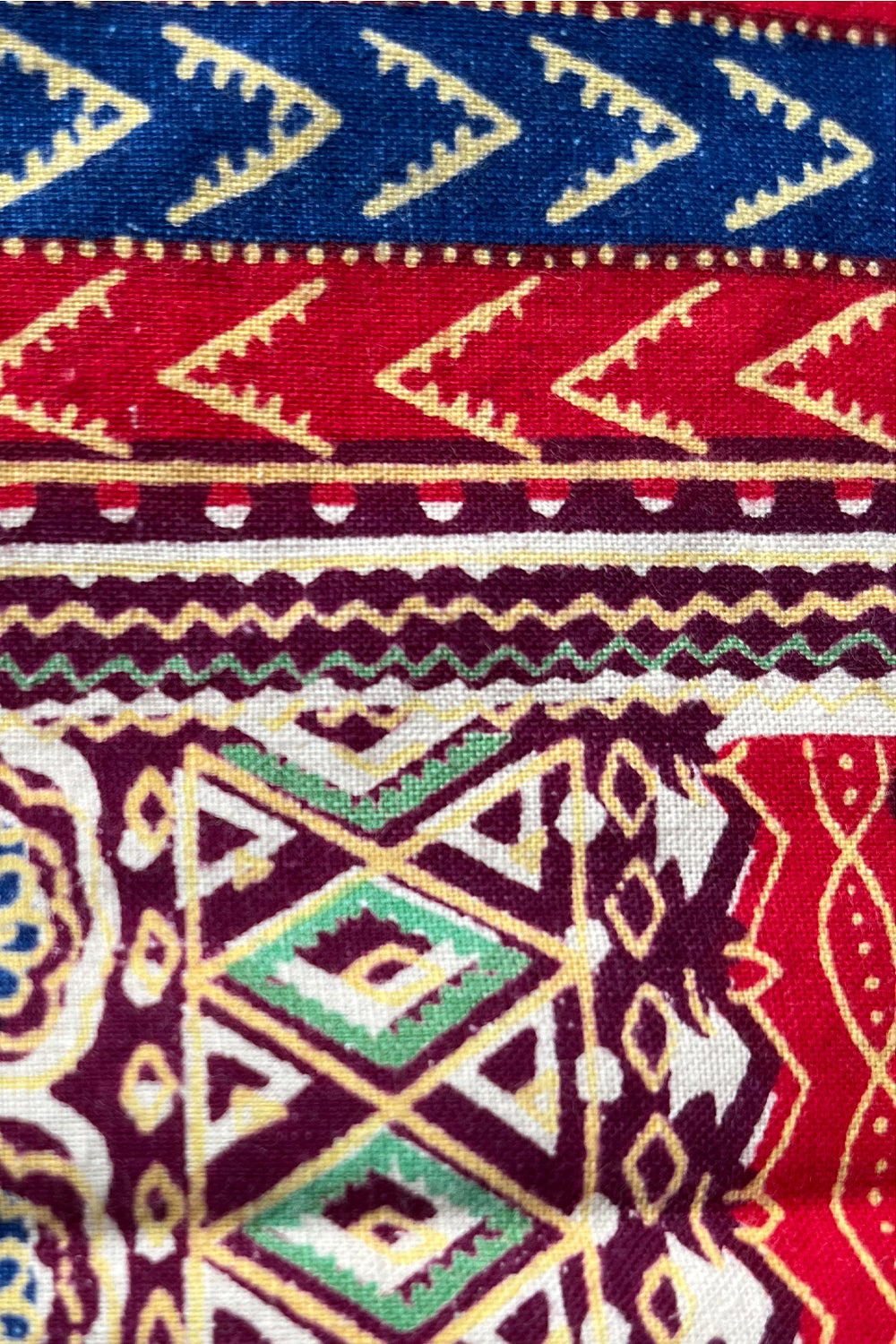 Close up stofstructuur vintage jaren 70 handgemaakte Dashiki tuniek in crème met kleurrijke print, katoenen top 