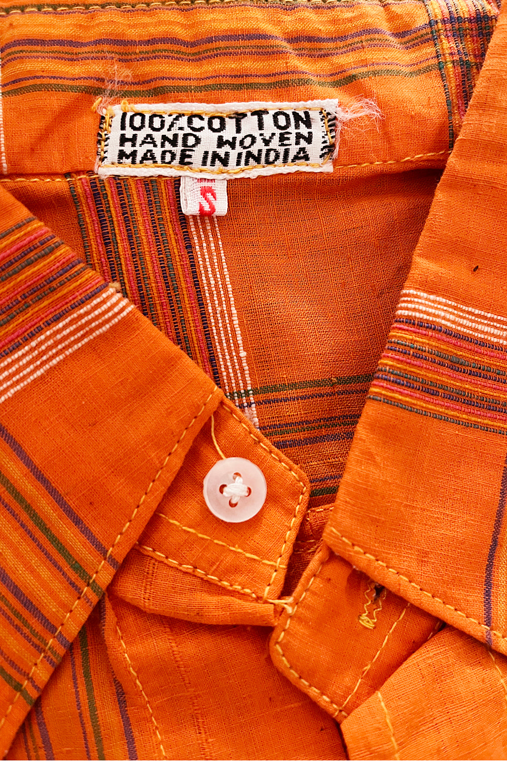 Close up stofstructuur vintage jaren 70 deadstock India blouse met puntkraag - handgeweven oranje katoenen getailleerd shirt