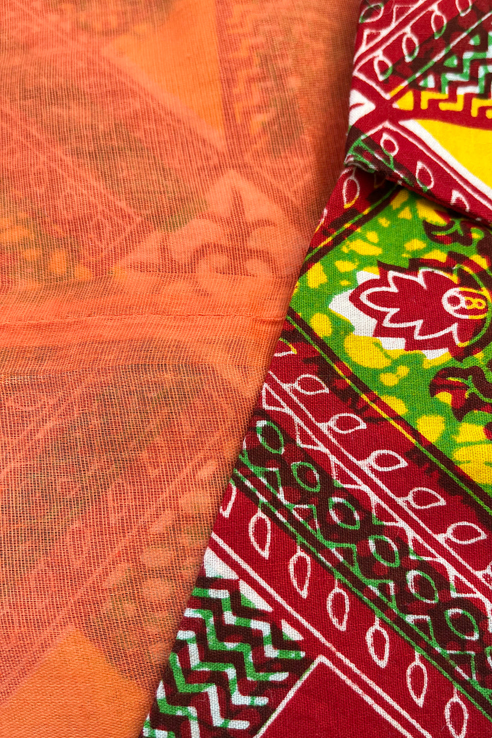 Vintage jaren 70 handgemaakte Afrikaanse batik peplum tuniek rood-groen-oranje-geel-wit detail voering - close-up van oranje gaaskatoen voering