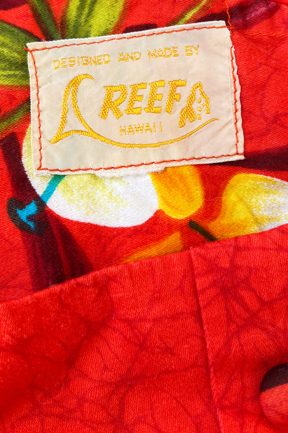 Vintage jaren 70 Hawaii jurk oranjerood-groen-geel-blauw-bruin-wit detail - close-up van Hawaii print patroon en label