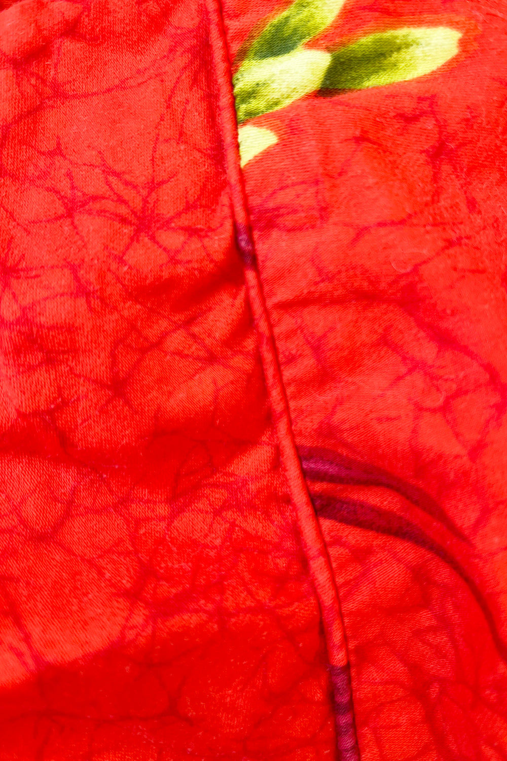 Vintage jaren 70 Hawaii jurk oranjerood-groen-geel-blauw-bruin-wit detail - close-up van Hawaii print en stiksel