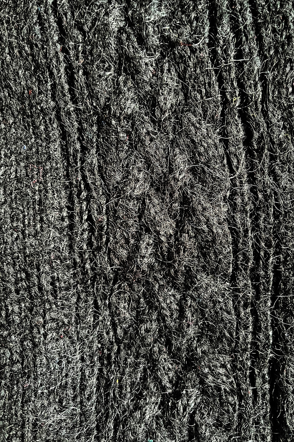 Nauwkeurige weergave gebreide zwarte mohair/acryl textuur van vintage 1980s oversized vest