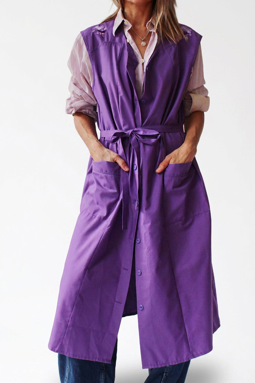 Paars vintage werkschort met strikceintuur in de taille, gedragen over een blouse en jeans.
