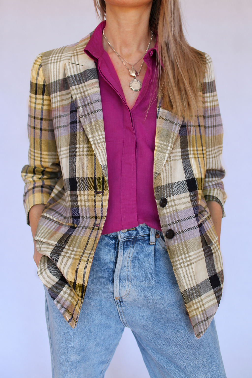 Vintage Rena Lange geruite blazer, gedragen met een paarse blouse en jeans, met de handen in de zakken.