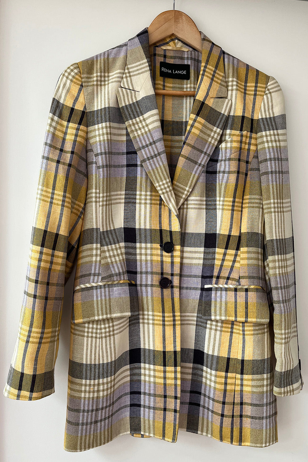  Vintage Rena Lange geruite blazer op een kledinghanger, met reverskraag, twee knopen en klepzakken.