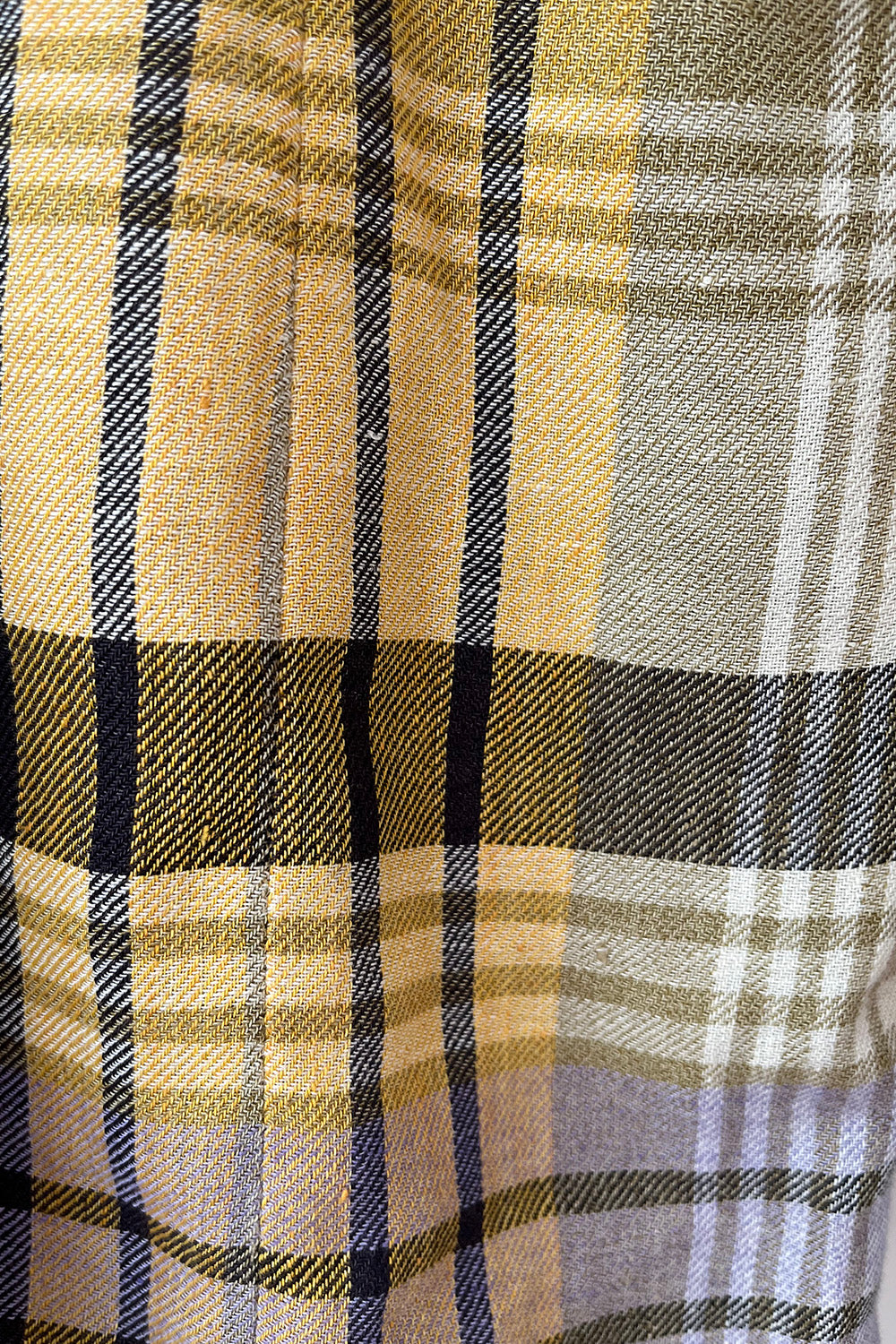Close-up van de geweven stof en het meerkleurige ruitpatroon van de vintage Rena Lange blazer.