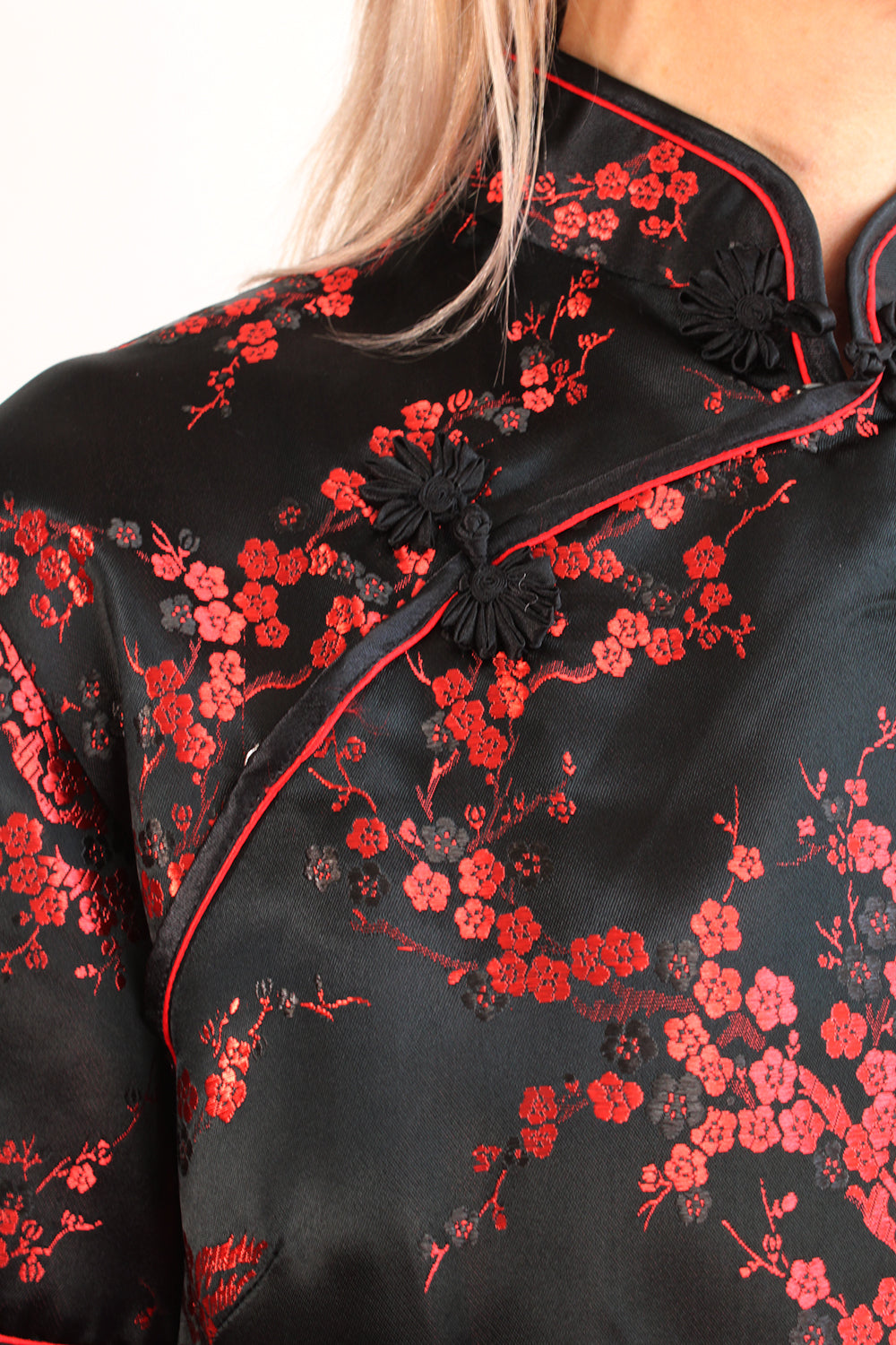 Vintage zijden Chinese cheongsam blouse zwart-rood detail - close-up van bloemenprint en diagonale sluiting met drukknoopjes stofknopen 