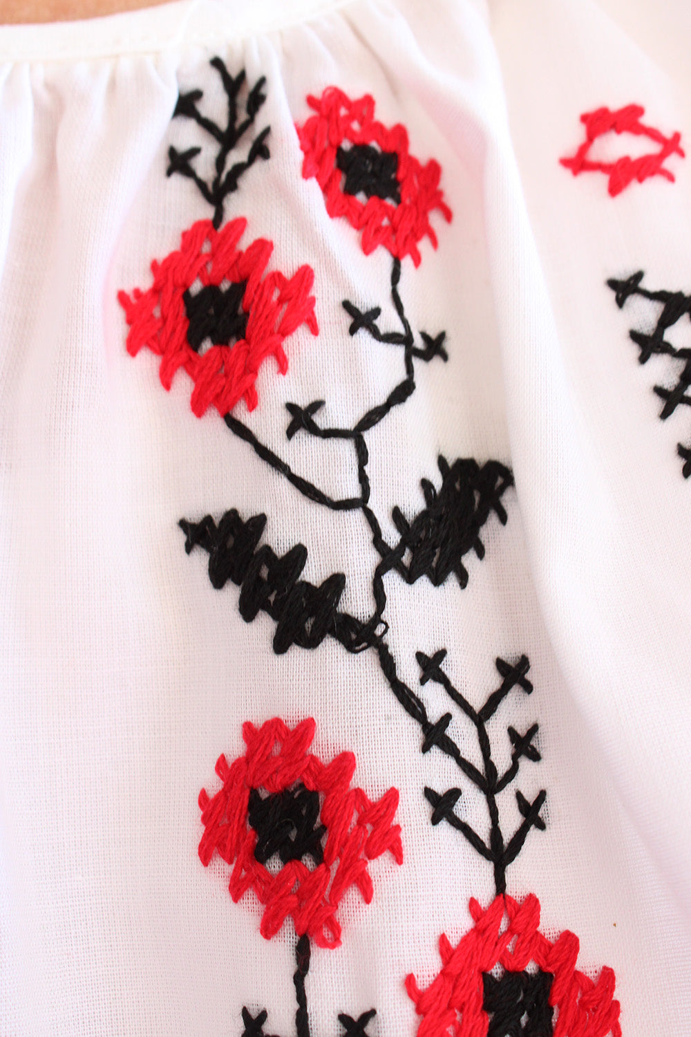 Vintage jaren 70 Bulgaarse geborduurde folklore bohemian blouse wit-multi detail - close-up van rood en zwart borduurwerk voorpand