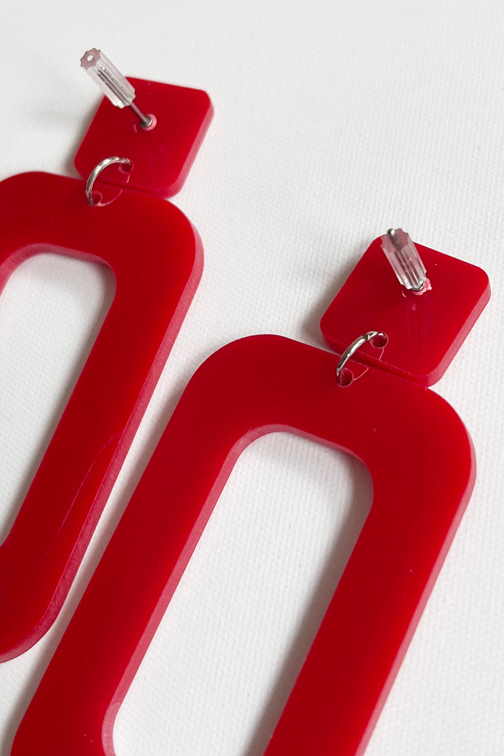 Vintage jaren 80 statement oorbellen rood detail achterkant - close-up van rode plastic oorbellen