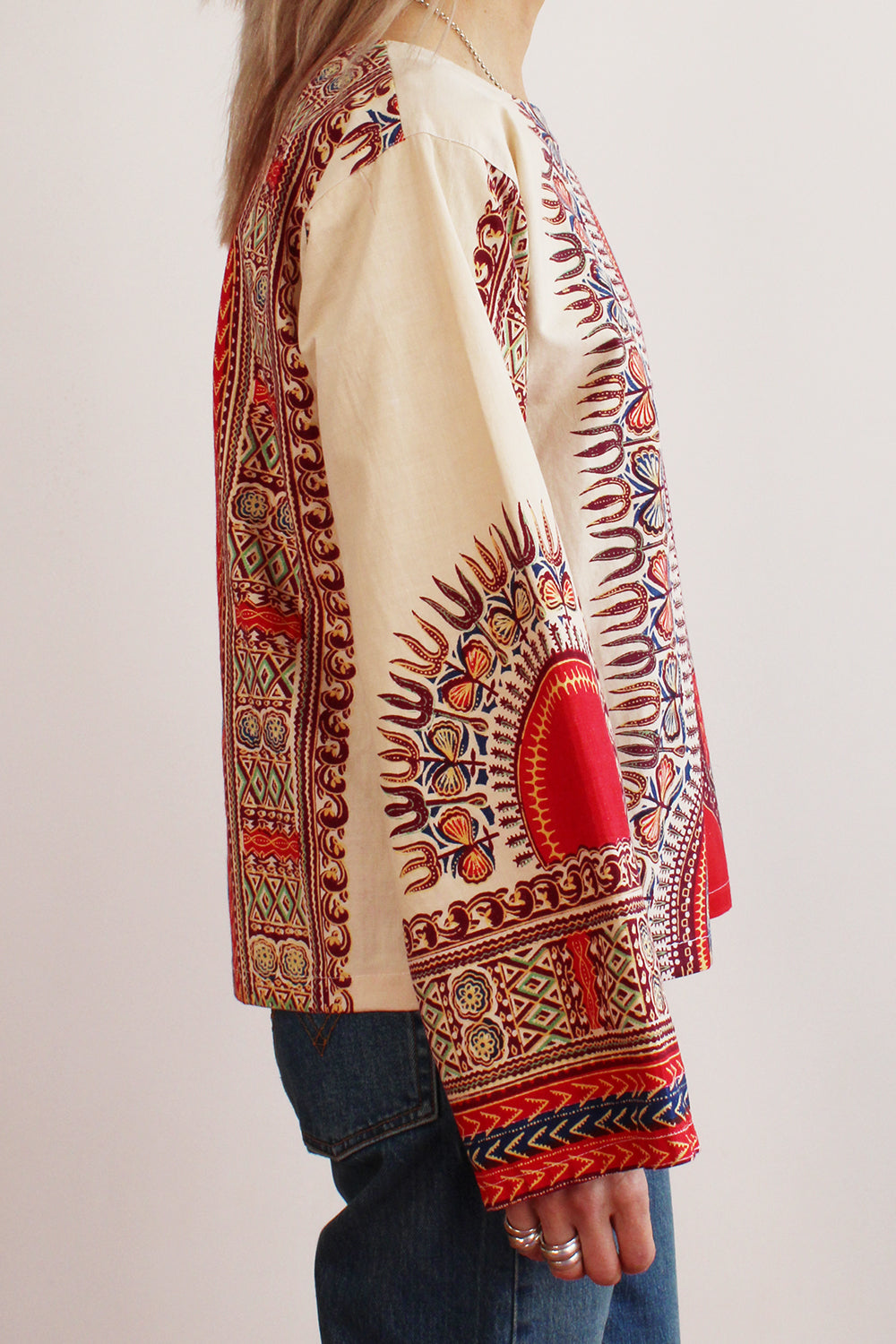 Zijaanzicht authentieke vintage jaren 70 handgemaakte Dashiki tuniek in crème met kleurrijke print, katoenen top met lange mouwen en ritssluiting