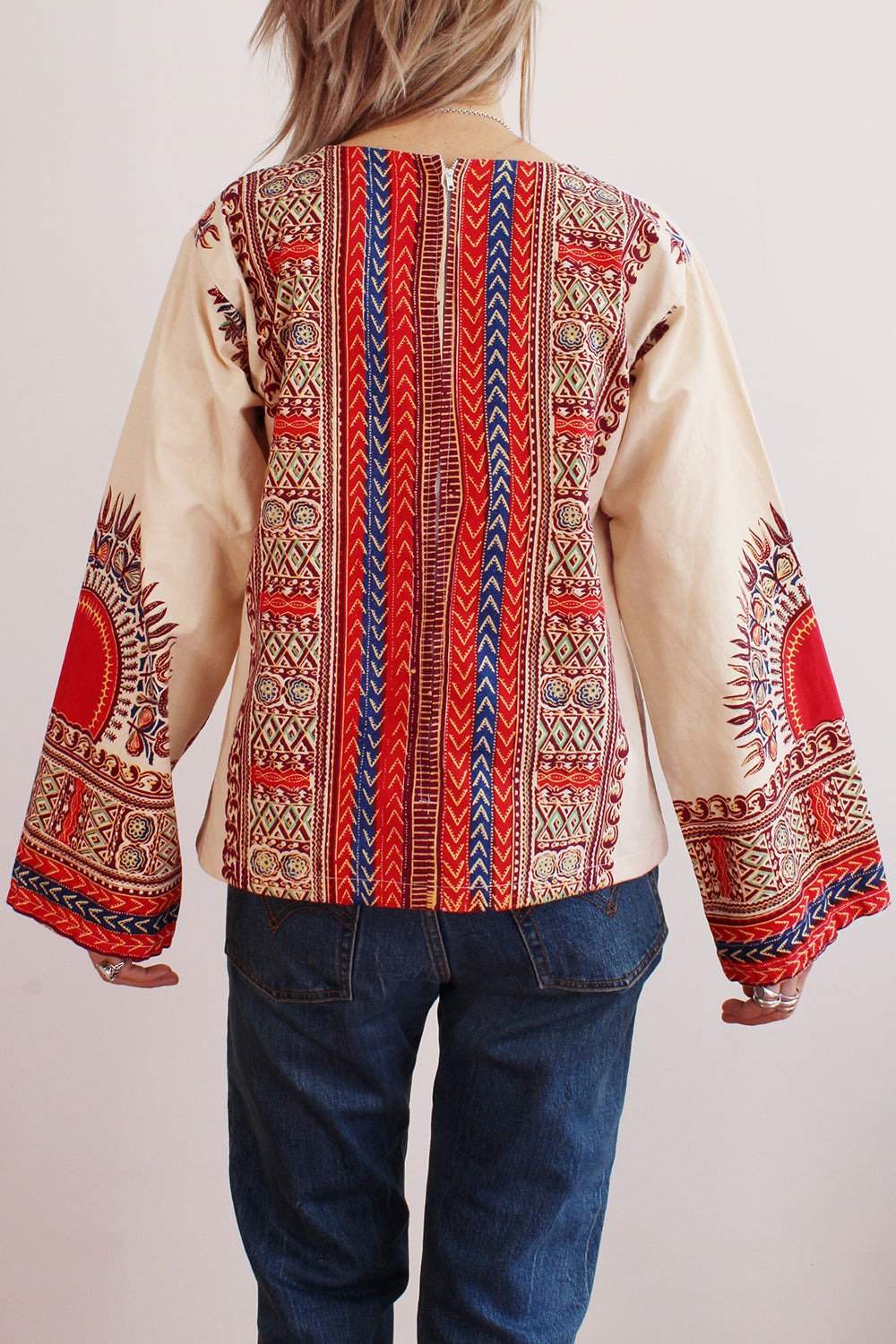 Achteraanzicht vintage jaren 70 handgemaakte Dashiki tuniek in crème met kleurrijke print, katoenen top met lange mouwen en ritssluiting
