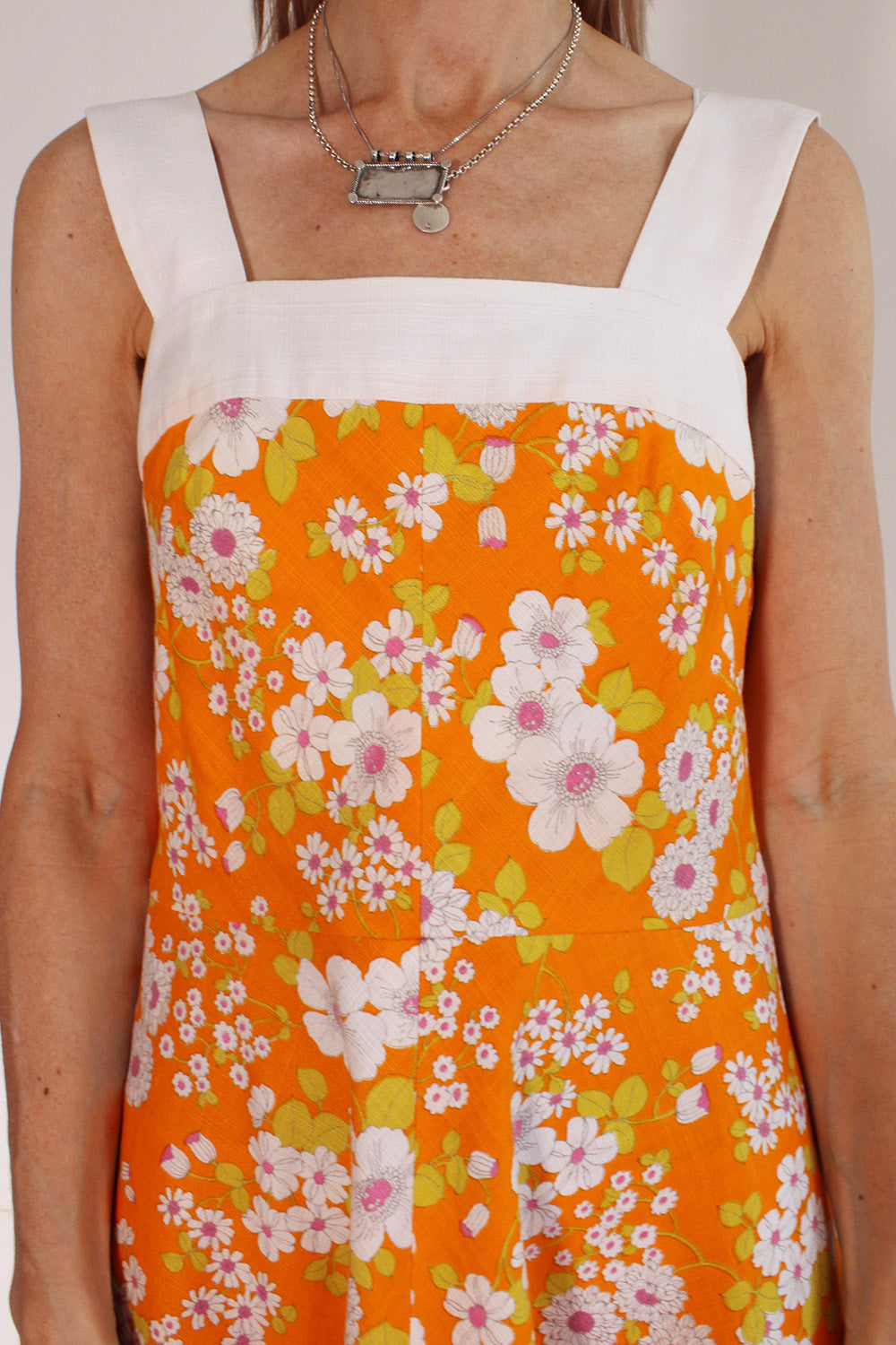 Vintage jaren 70 handgemaakte jurk oranje-roze-groen-wit met bloemenprint detail schouderbanden - close-up van brede witte schouderbanden