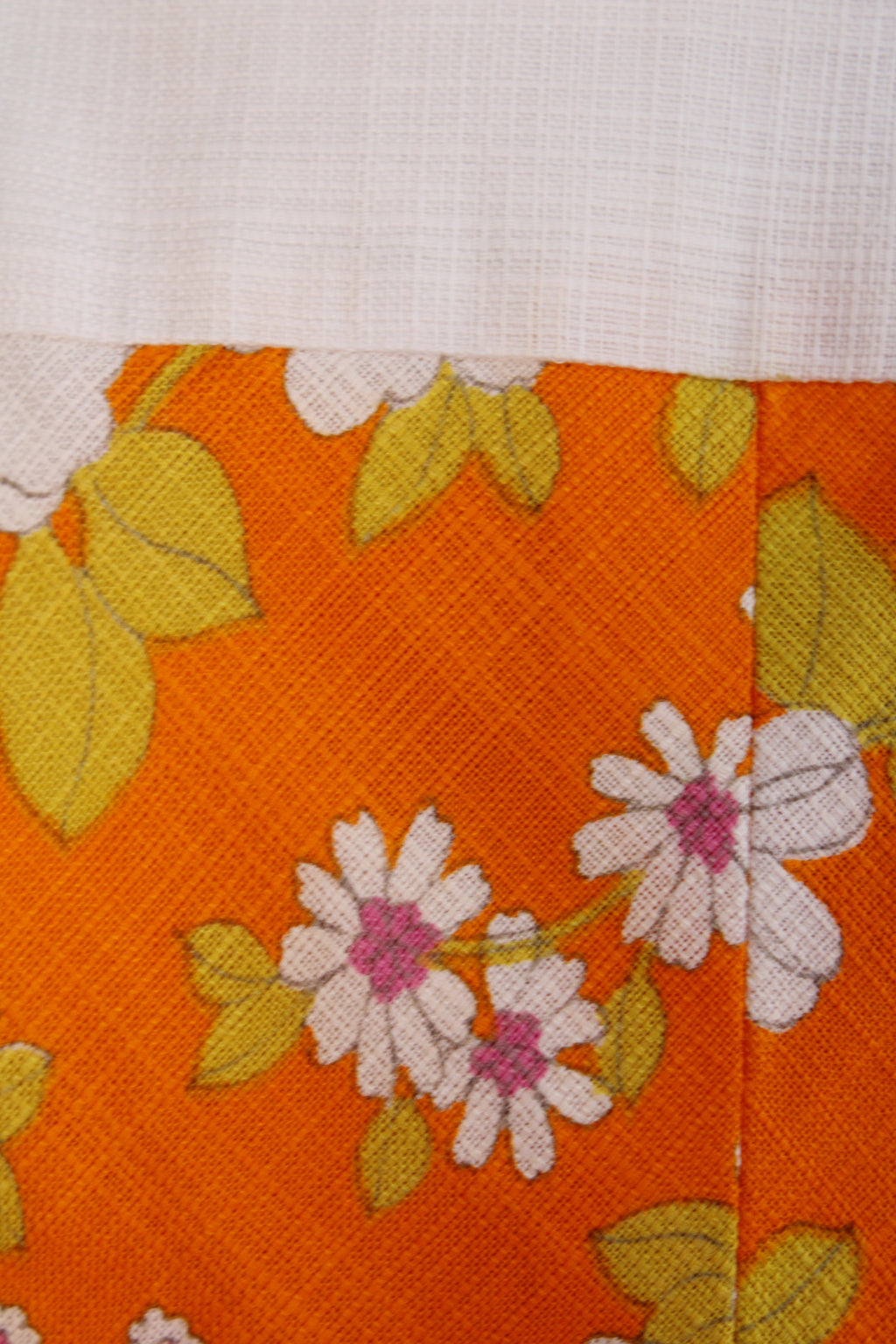 Vintage jaren 70 handgemaakte jurk oranje-roze-groen-wit met bloemenprint detail - close-up van bloemenprint patroon