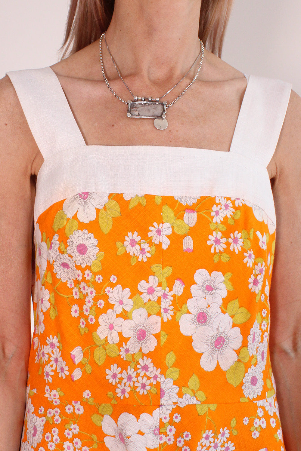 Vintage jaren 70 handgemaakte jurk oranje-roze-groen-wit met bloemenprint detail schouderbanden - close-up van brede witte schouderbanden en stofstructuur