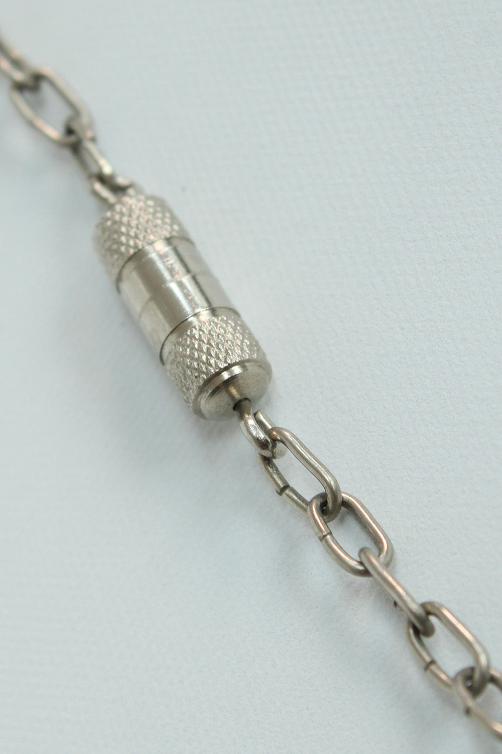 Vintage jaren 70 kralenketting zwart-donkerpaars detail sluiting - close-up van metalen draaislotje