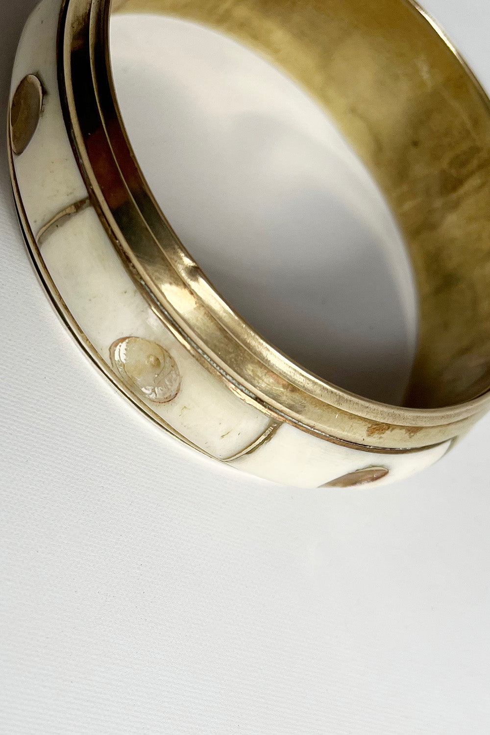 Vintage koperen armband met bot uit de jaren 70, detail van de koperen plaatjes en het bot