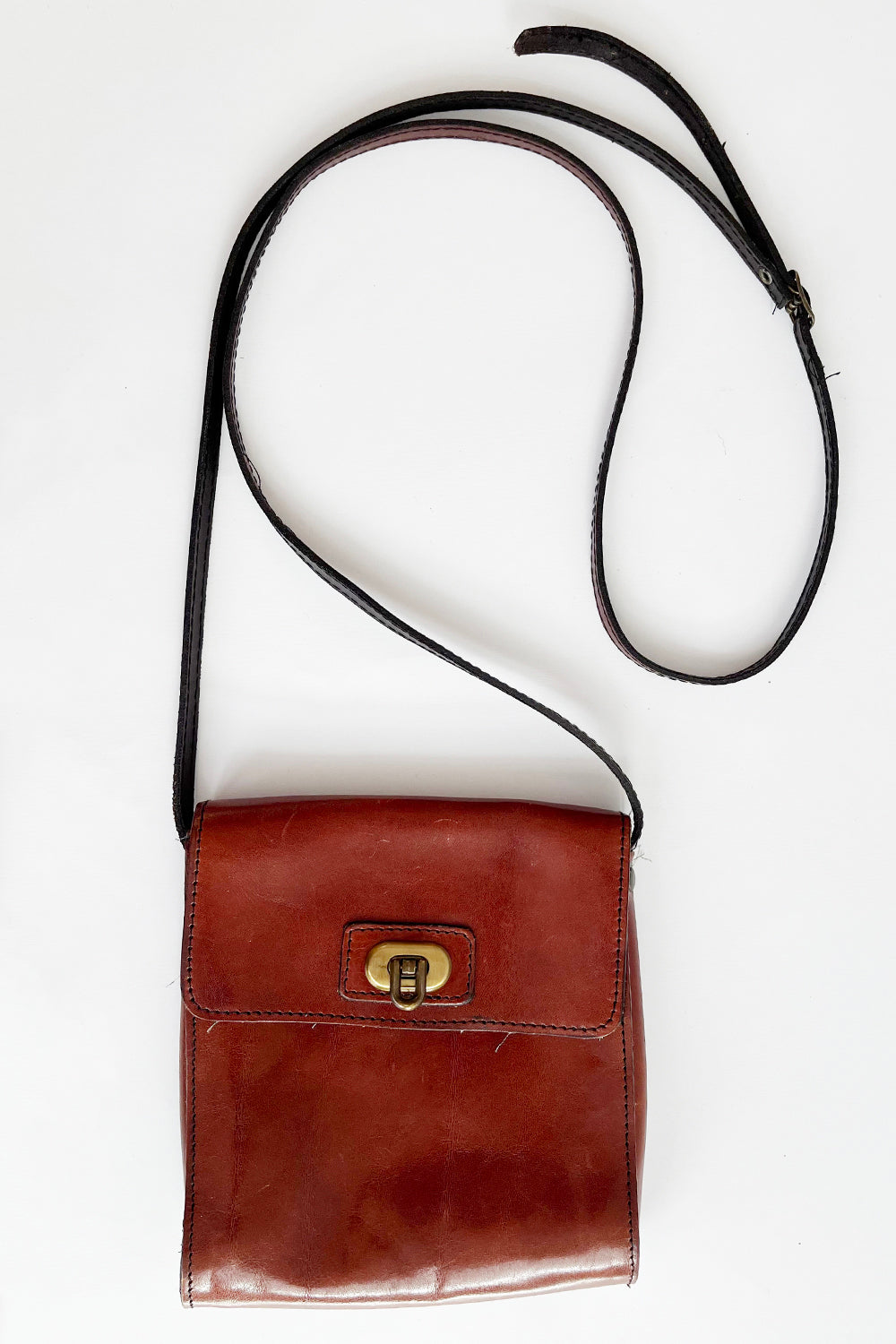 Vintage bruine leren crossbody tas jaren 80 met gouden draaisluiting en lang verstelbaar hengsel – totaaloverzicht