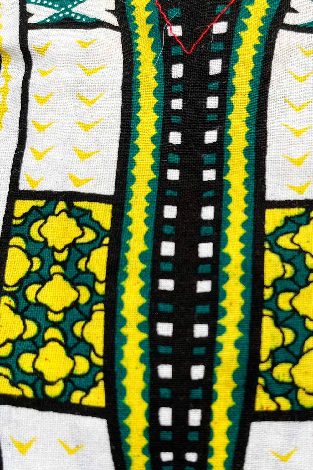 Vintage jaren 90 dashiki print tuniek rood-multi detail - close-up van dashiki print  en stofstructuur