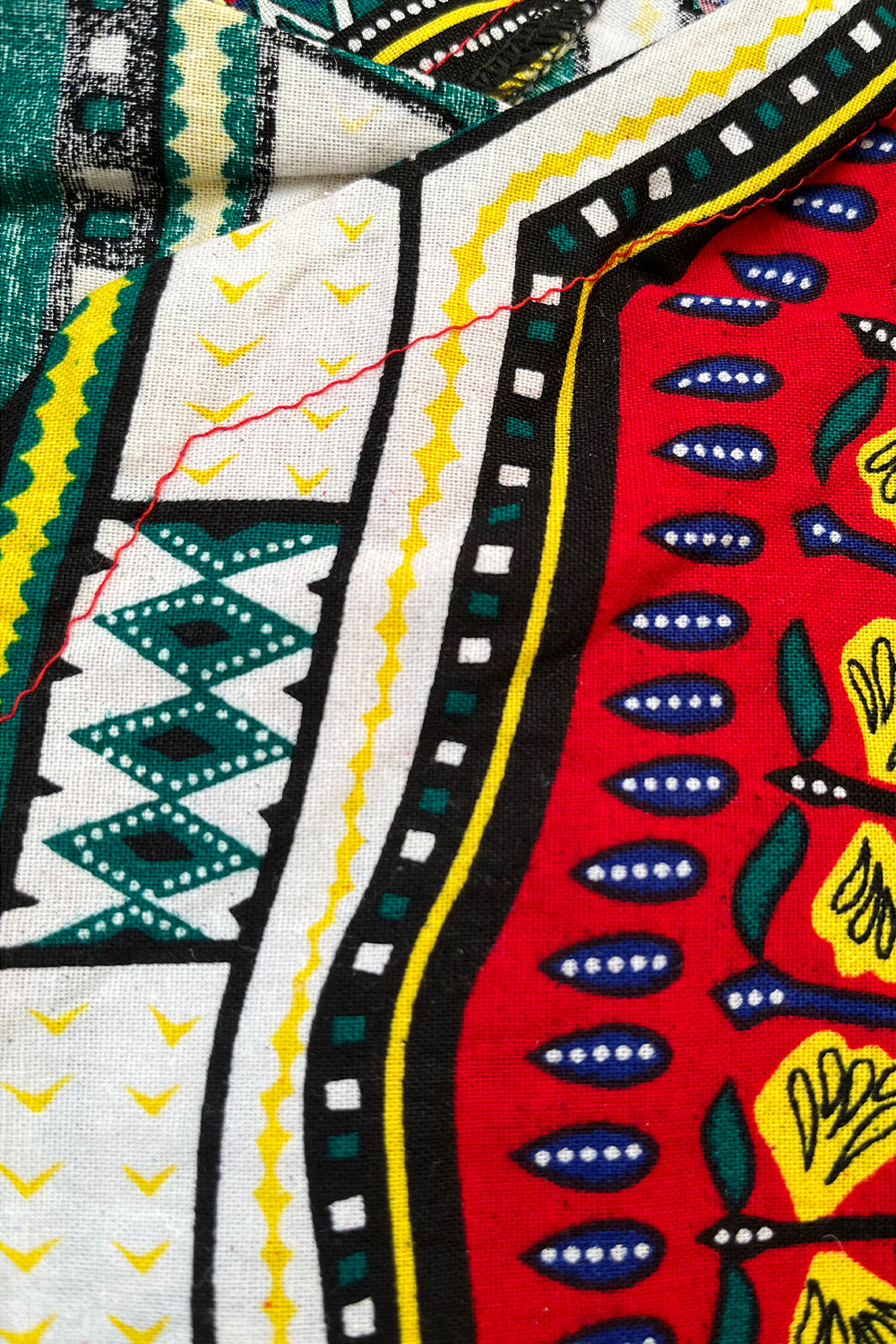 Vintage jaren 90 dashiki print tuniek rood-multi detail print - close-up van dashiki print detail 