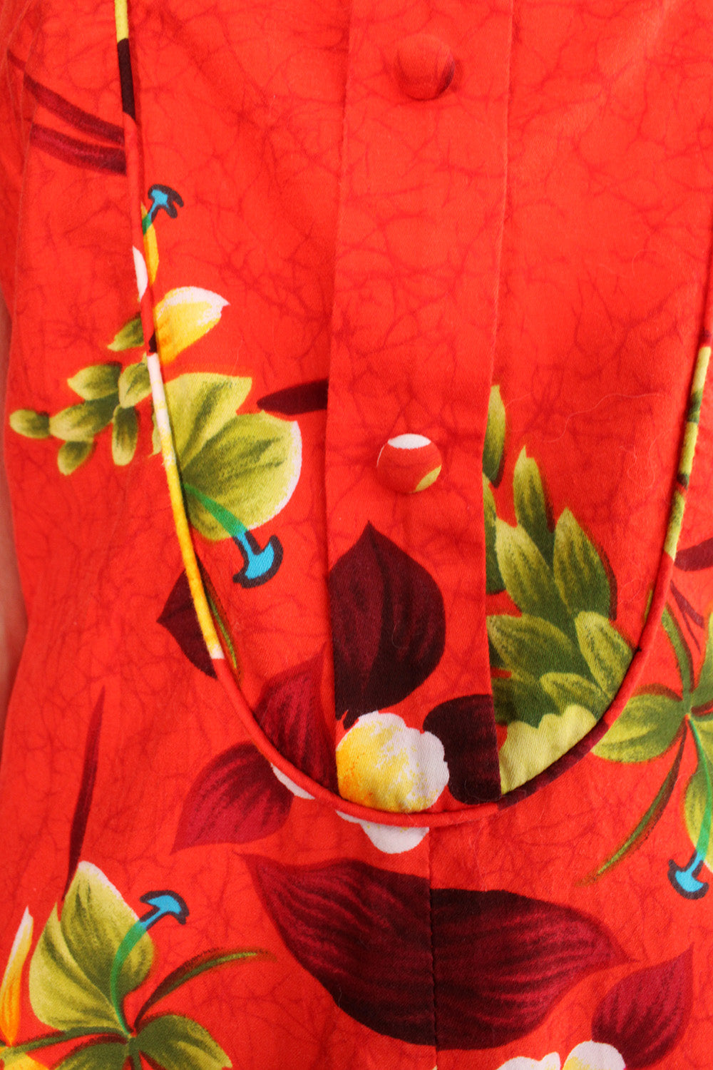 Vintage jaren 70 Hawaii jurk oranjerood-groen-geel-blauw-bruin-wit detail - close-up van Hawaii print patroon en sluiting