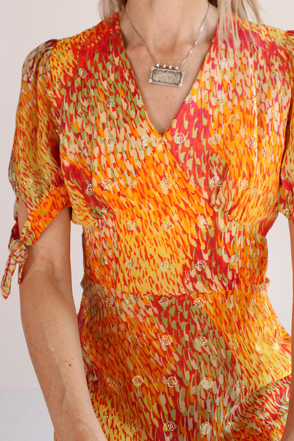 Vintage jaren 70 Vera Mont avondjurk oranje-geel-rood-groen-goud detail pofmouwtjes - close-up van pofmouwtjes met strik en hals