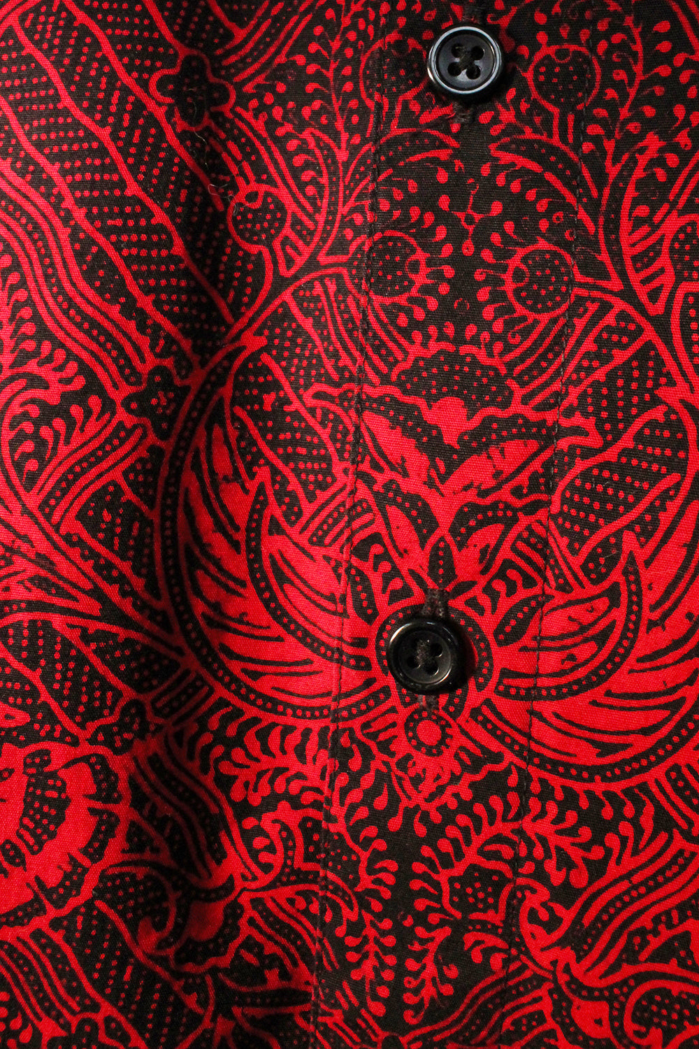 Vintage jaren 90 handgemaakte oversized batik blouse rood-zwart detail - close-up sluiting Batik blouse voorkant