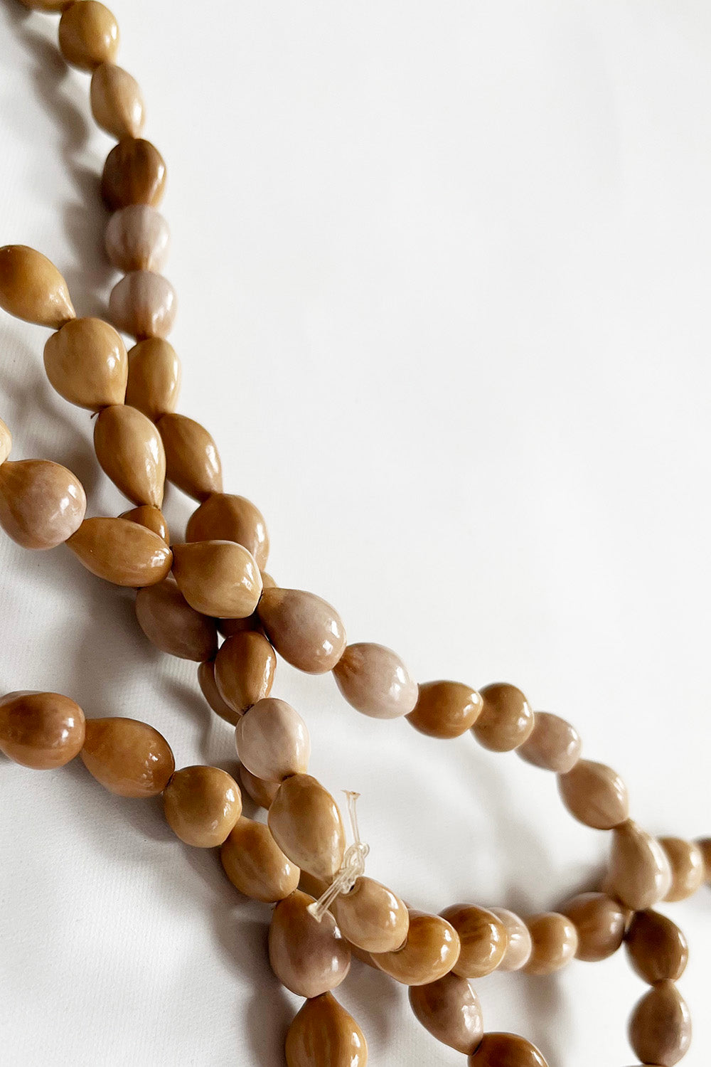 Vintage handgemaakte pitten ketting beige detail - close-up van pitten kralen 