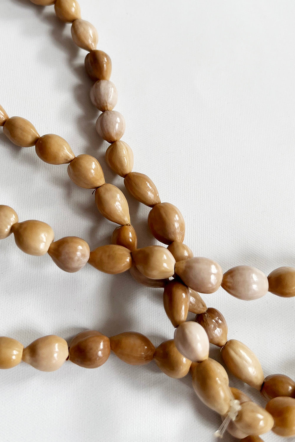Vintage handgemaakte pitten ketting beige detail - close-up van pitten kralen 