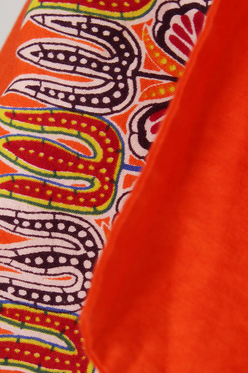 Vintage jaren 70 handgemaakte dashiki halterjurk oranje-multi detail - close-up van dashiki print patroon