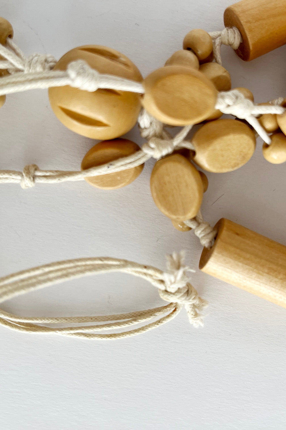 Vintage handgemaakte houten kralenketting beige-off white detail - close-up van houten kralen en katoenen hanger