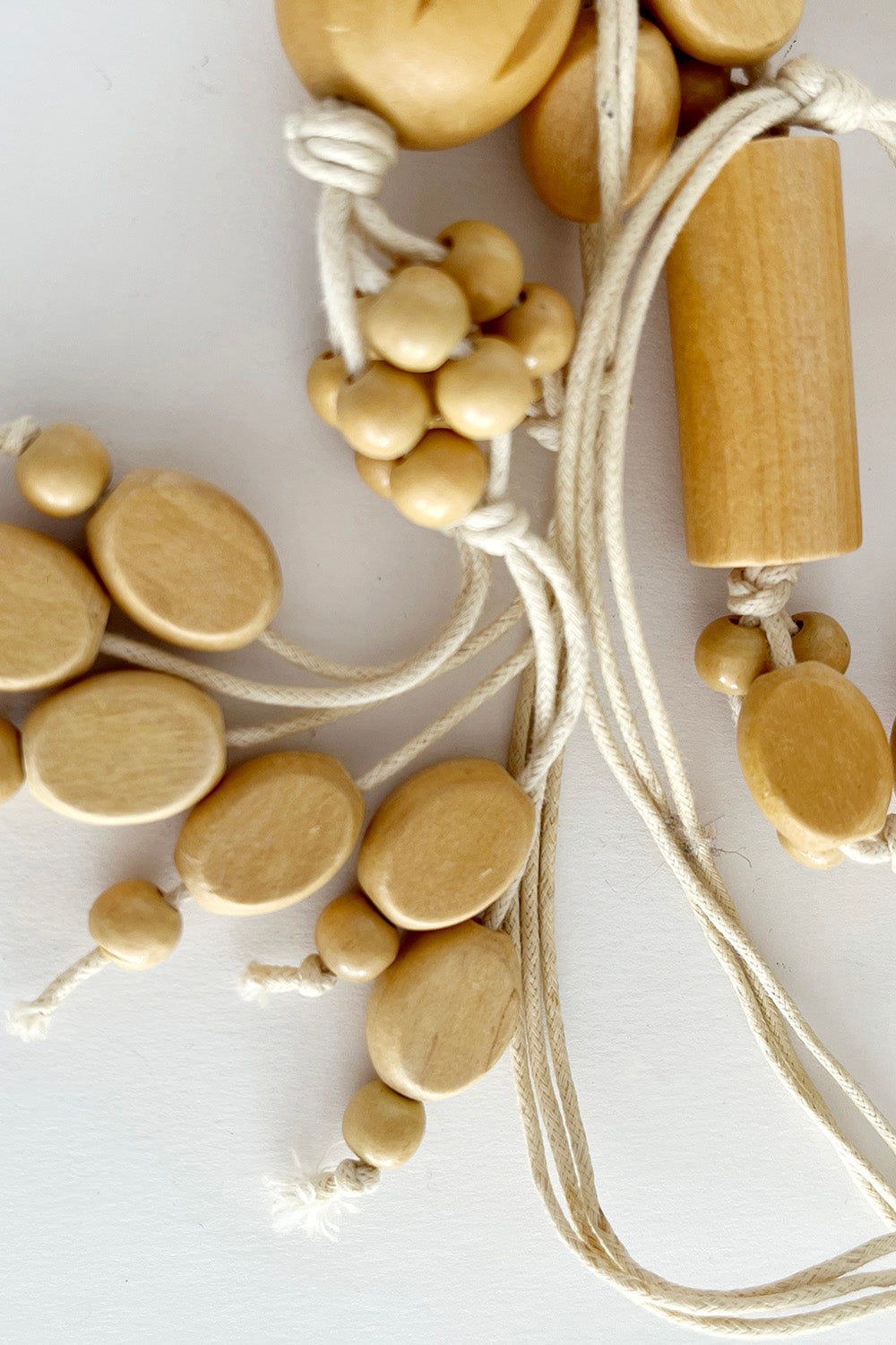 Vintage handgemaakte houten kralenketting beige-off white detail hanger - close-up van katoenen hanger 14 cm