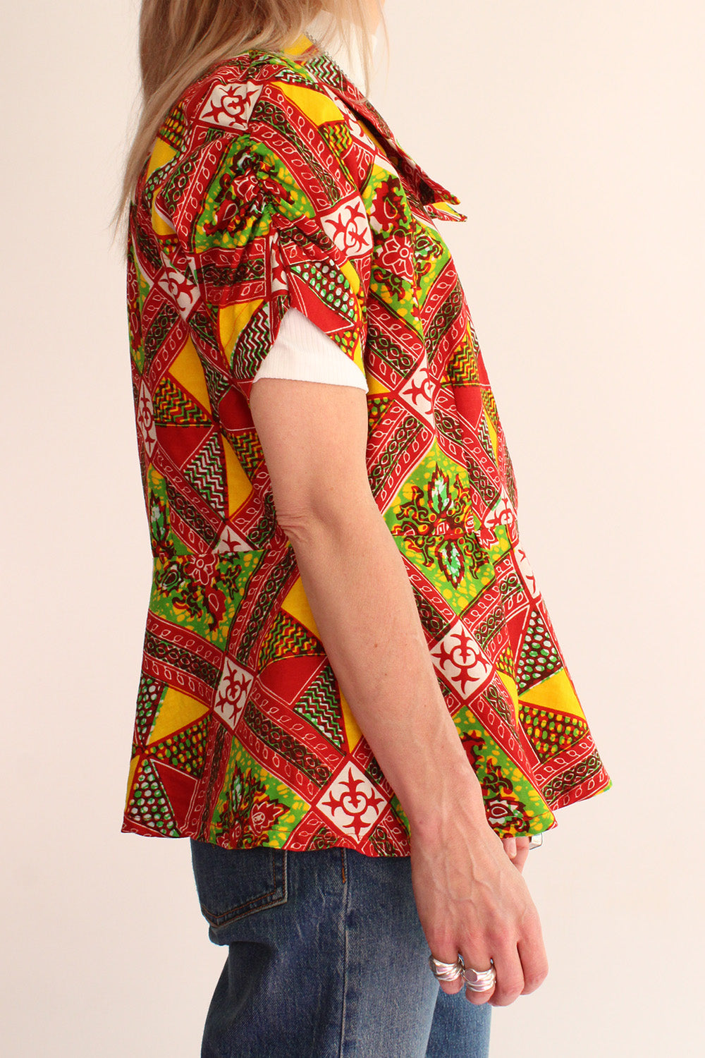 Vintage jaren 70 handgemaakte Afrikaanse batik peplum tuniek rood-groen-oranje-geel-wit gedragen zijkant - katoenen tuniek met gerimpeld mouwtje