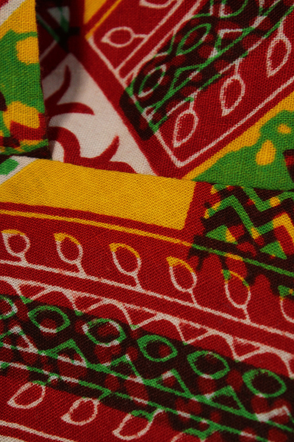 Vintage jaren 70 handgemaakte Afrikaanse batik peplum tuniek rood-groen-oranje-geel-wit detail - close-up van batik print patroon