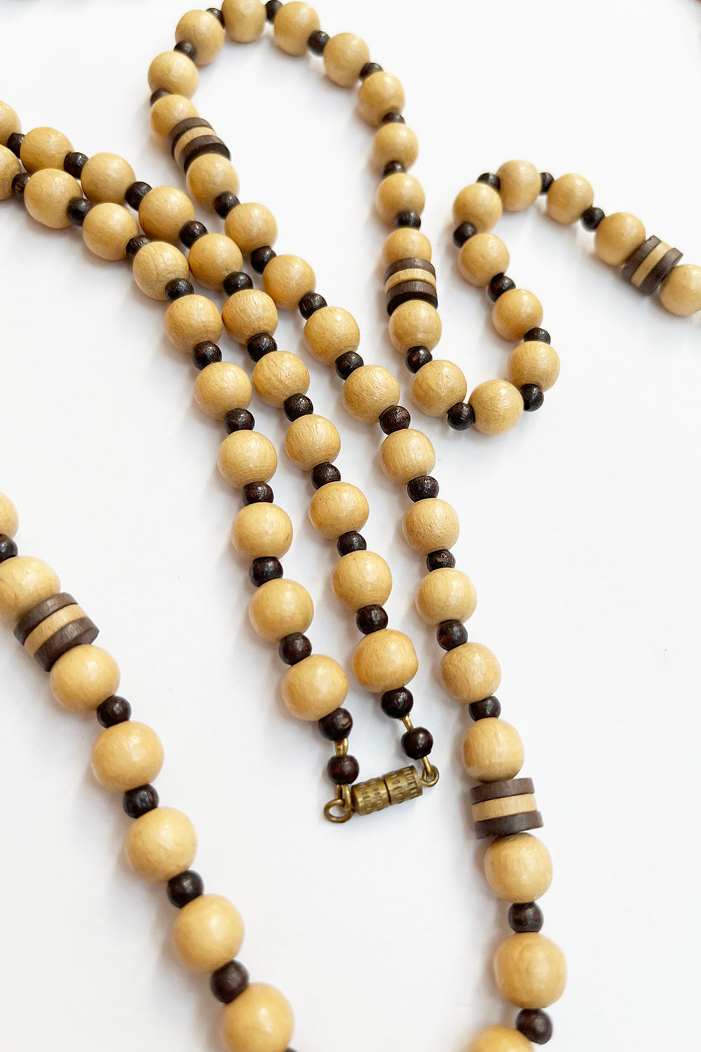 Vintage houten kralenketting beige-bruin detail - close-up van houten kralen en metalen draaisluiting