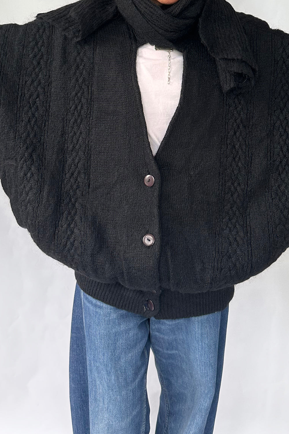 Close-up van grote plastic knopen en grof gebreid mohair/acryl textuur vintage oversized vest