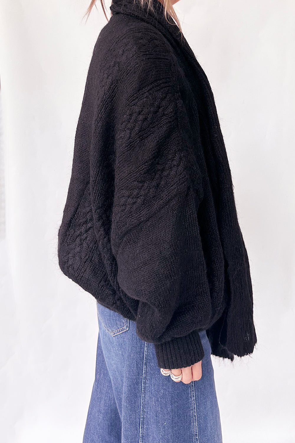 Zijkant van vintage oversized 1980s gebreid vest in zwart met diepe zijzakken en volumineuze pasvorm
