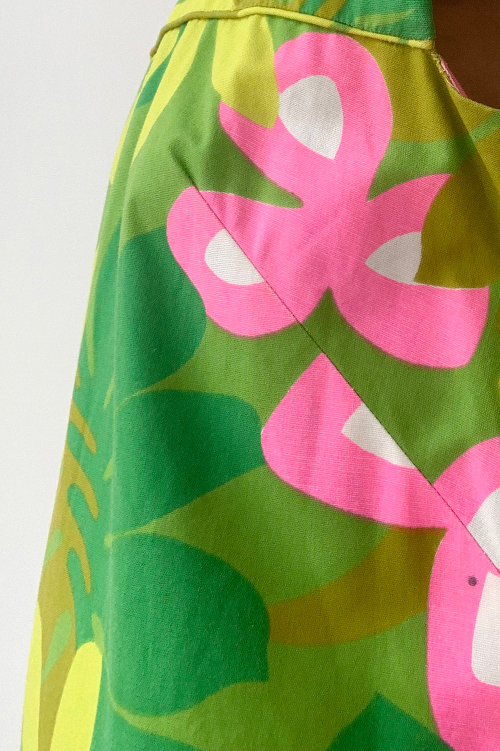 Vintage jaren 60 handgemaakte Hawaii jurk groen-multi met floral print detail - close-up van Hawaii floral print patroon met klein vlekje zijkant