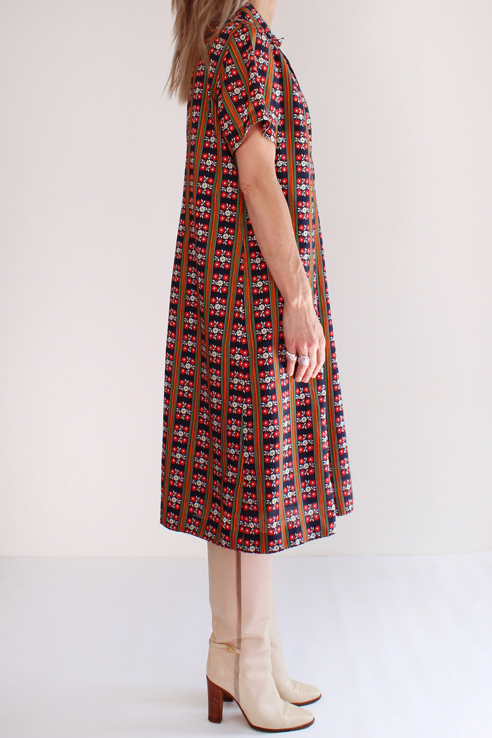 Vintage jaren 60 jurk donkerblauw-rood-geel-groen-wit met print gedragen zijkant - katoenen wijd uitlopende jurk