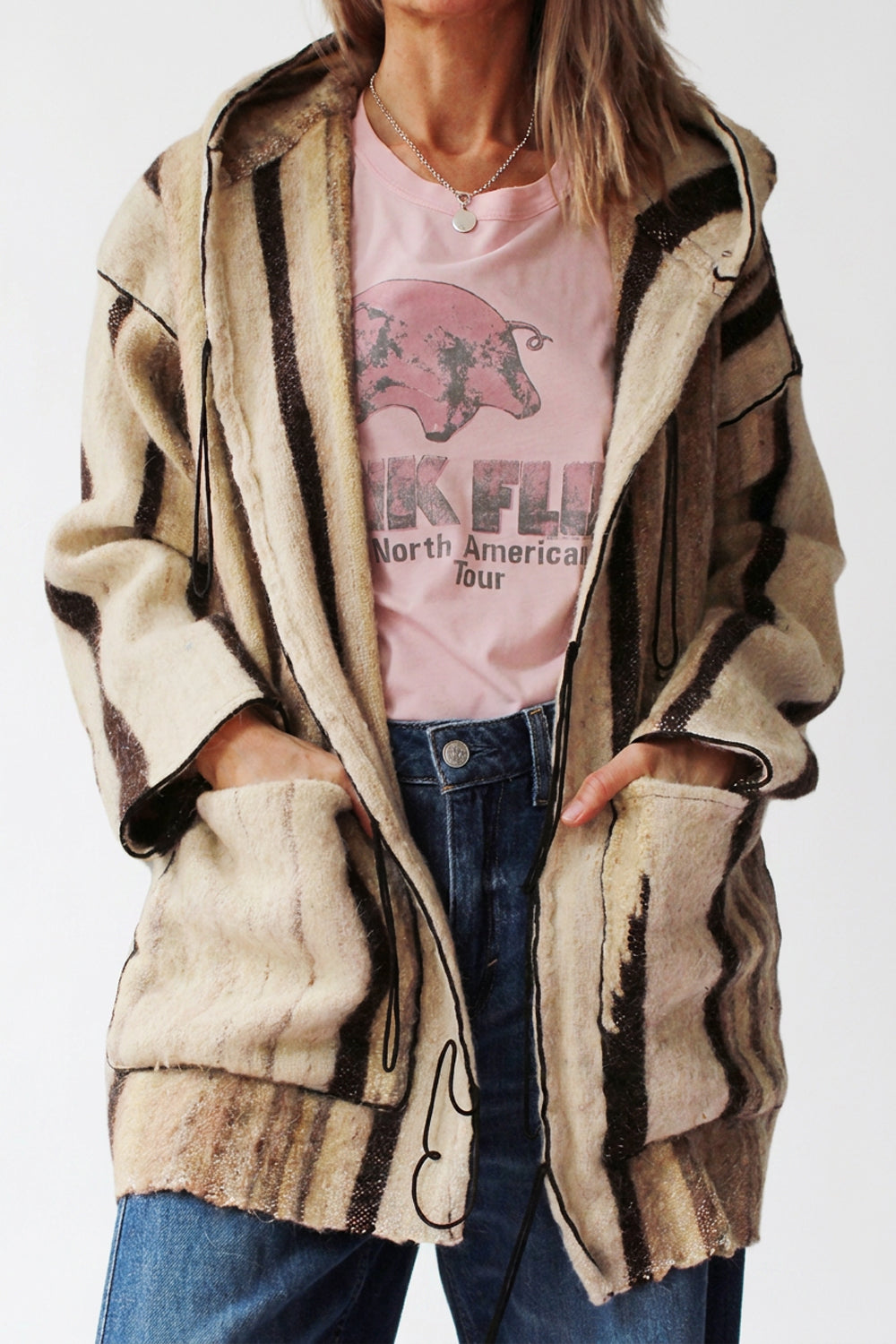 Oversized vintage wollen dekenjas met grote capuchon en koordjes — vooraanzicht, handen in de zakken